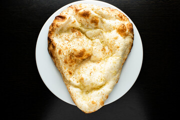 Tandoori Garlic Naan, nan, nun, bread or roti served in dish isolated dark background top view of indian spices, bangladeshi and pakistani food