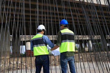 Pile Construction, Civil engineer working with blueprint drawing at steel frame for pile construction site of the infrastructure of the new bridge highway project