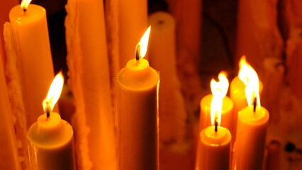 A serene display of warm candles casting soft light in a dim setting, perfect for tranquility, ambiance, and relaxation.