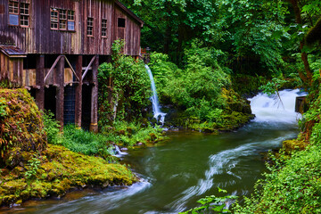 Fototapeta premium Cedar Creek Grist Mill and Waterfall with Flowing River Eye-Level View