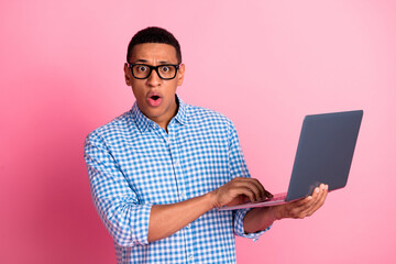 Photo of impressed shocked guy dressed checkered shirt texting modern device emtpy space isolated pink color background