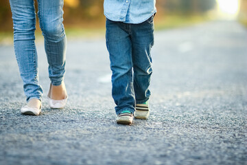 A Happy parent with child are walking along the road in the park on nature travel