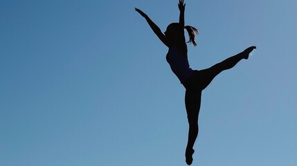 A woman suspended in mid-air, silhouetted against a clear blue sky, gracefully executing a warrior three pose with arms outstretched and one leg extended back.
