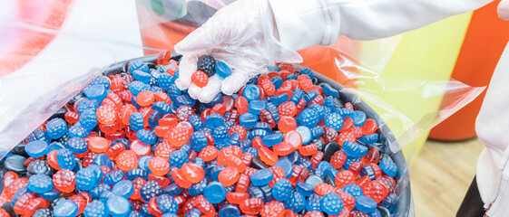 A person is holding a handful of fruit-flavored gummy bears