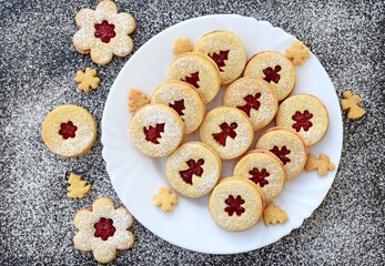 Linzer cookies on a plate and around it