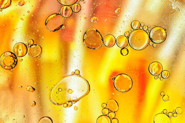 Abstract yellow background with oil, water and bubbles