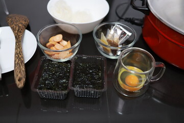 Women prepare ingredients and prepare breakfast sandwiches, fried eggs, and toast for the family
