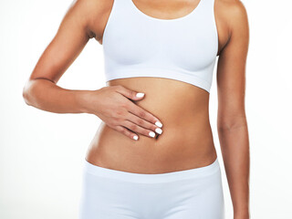 Hand, stomach and body of woman in studio with weightloss for fitness, diet or digestion. Gut...