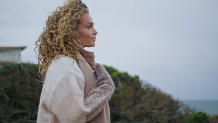 Dreamy woman contemplating windy seascape at vacation close up. Romantic lady