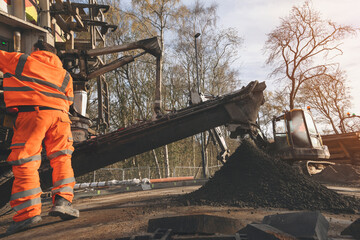 Construction Worker Operating Heavy Machinery During Road Repair