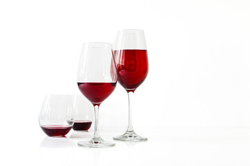 Three glasses of red wine on a white background
