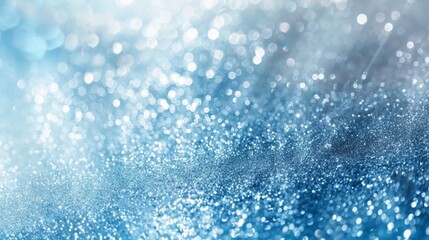 Fototapeta premium Abstract blue background with sparkling glitter and defocused bokeh lights creating a magical atmosphere for festive occasions