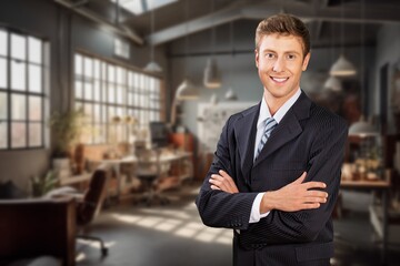 Happy confident business man standing in office