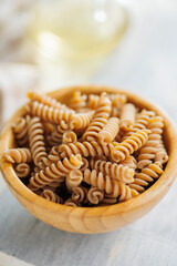 Uncooked whole grain pasta. Raw fusilli in bowl.