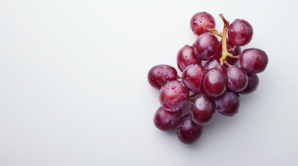 A bunch of ripe red grapes with water drops on a white background.