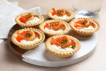 Delicious canapes with shrimps, red caviar and cream cheese on light table