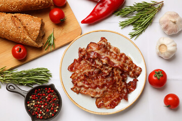 Slices of tasty fried bacon, tomatoes, different spices and bread on white table, flat lay