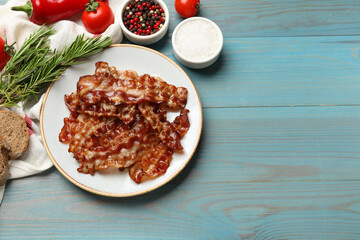 Slices of tasty fried bacon, different spices and bread on light blue wooden table, top view. Space for text