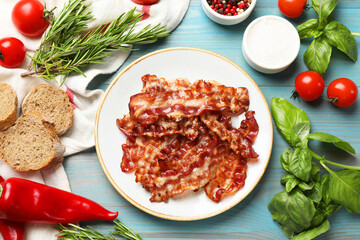 Slices of tasty fried bacon, tomatoes, different spices and bread on light blue wooden table, top view