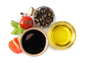 Balsamic vinegar in bowl, oil, tomatoes, basil and spices isolated on white, top view
