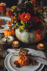 Atmospheric autumn elegant beautiful table setting with pumpkins for a wedding or thanksgiving family celebration. Fall decoration countryside rustic style, cozy home atmosphere , candles, wine