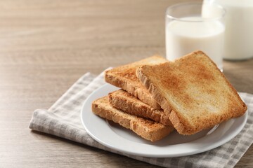 Delicious toasts with milk on wooden table