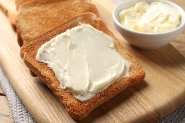 Delicious toasted bread slices with butter on table, closeup