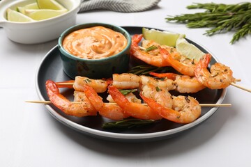 Skewers with delicious grilled shrimps served on white table