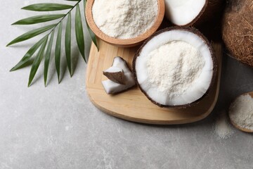 Organic coconut flour, fresh fruits and leaf on light grey table, flat lay. Space for text