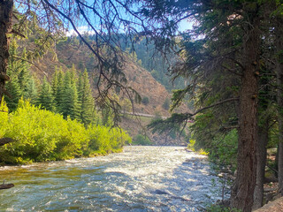 Clear Creek river running downstream on a bright morning in July.