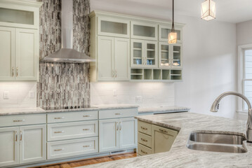 Modern Kitchen With Light Cabinetry And Marble Countertops Plus Island Area