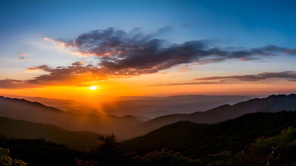 Obraz premium a-serene-sunset-scene-with-the-sun-setting-behind-a-mountain-range-casting-a-warm-glow-over