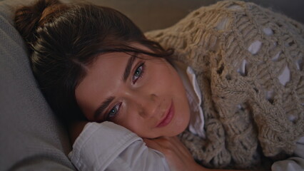 Closeup sleepy girl napping evening apartment. Woman resting sofa in tv light