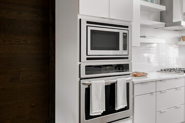 Modern Kitchen With Built-In Stainless Steel Microwave And Oven, White Cabinets