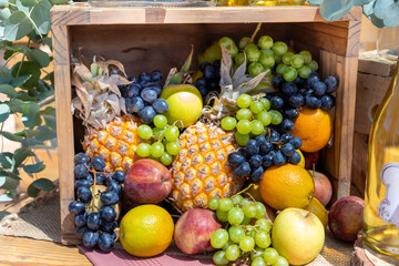 Selection of different summer fruits in a square wooden basket. 