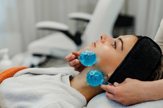 The master gives the client a relaxing facial massage using cold cryo spheres.