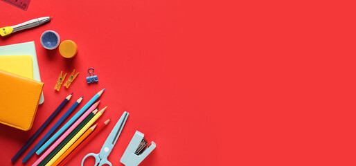School supplies with colorful pencils on red background. Top view