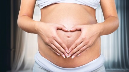 Pregnant young woman holding hand on belly