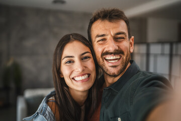 Self portrait of happy couple hug and have fun at home
