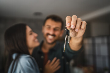 Close up of hands of couple hold key of their new home
