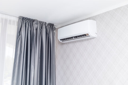 White Air Conditioner Mounted On Wall Decorated With Wall Paper Inside The Condo, House or Hotel. Hvac System. Smart Air Conditioning Blowing Cold Air In The Room For Home. Horizontal.