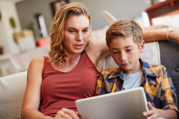 Mom, family and boy on tablet and sofa for online education, reading ebook or e learning support or help at home. Woman, house and mother with child on problem solving games or immersive digital app