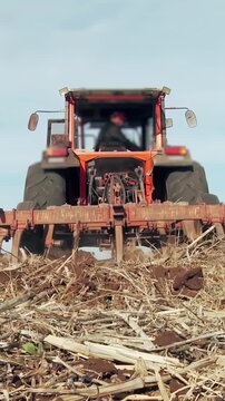 Farm Tractor Plowing a Field in Argentina. Low Angle View.  