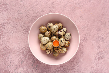Bowl with fresh quail eggs on pink background