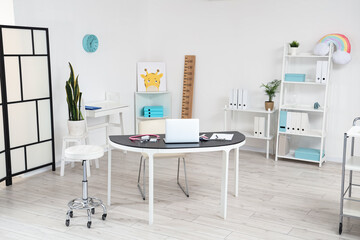 Interior of pediatrician's office with workplace and shelf units