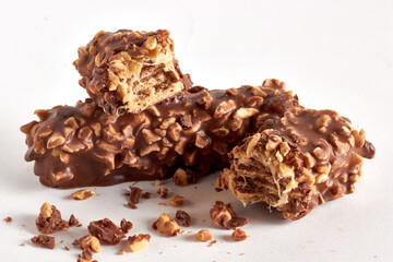 Wafer bar with soft caramel covered with nuts and chocolate. Internal section at fracture