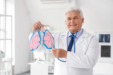 Mature doctor with stethoscope and paper lungs in clinic