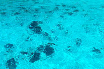 Texture of blue water under sun beams.