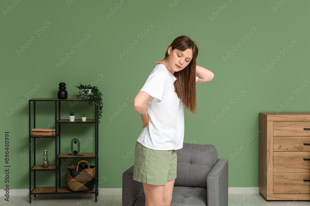 Canvas Prints Young woman suffering from back pain in living room