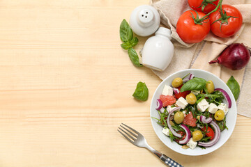 Bowl with healthy vegetable salad, fork and ingredients on wooden background